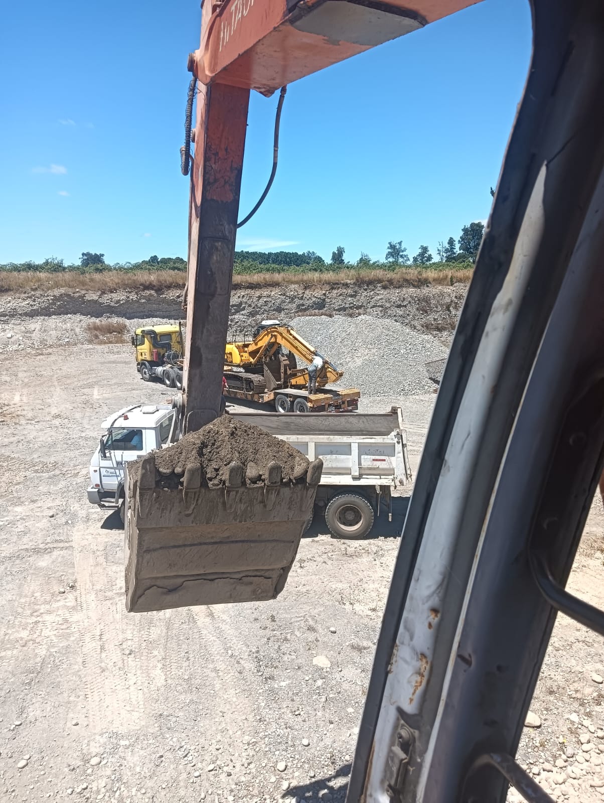 Excavadora cargando camión tolva con áridos, sur de Chile